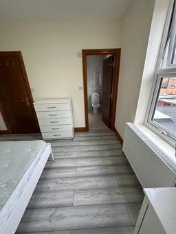 Bedroom with drawers and doorway through to a private shower room