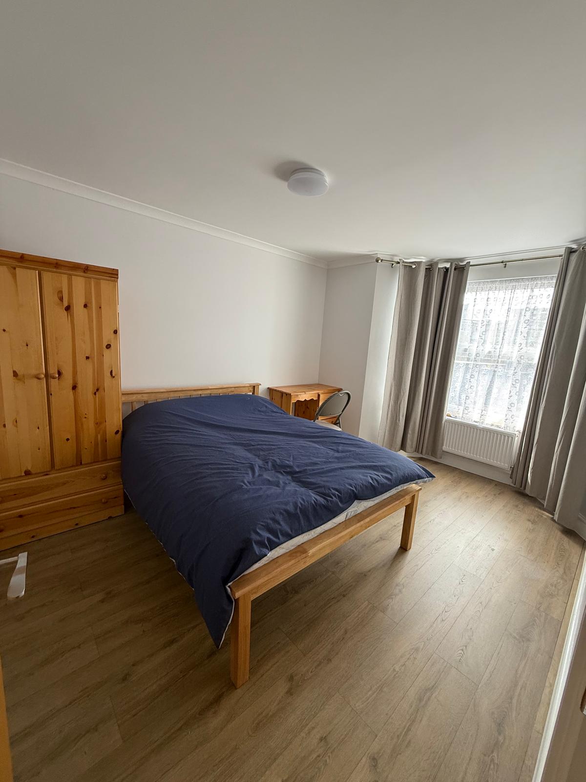 Spacious double bedroom with pine wardrobe and desk